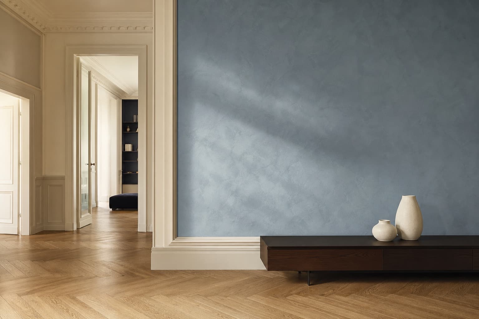 Interno milanese rinnovato con parete materica azzurro polvere e finiture color crema